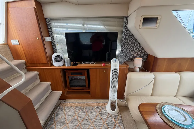 Slide: The Image of Interior of a 1999 Silverton 352 Motor Yacht with TV, fan, and cozy seating area. - 53