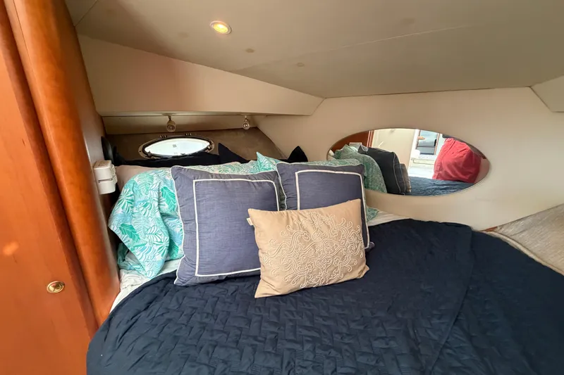 Slide: The Image of Cozy bedroom interior of 1999 Silverton 352 Motor Yacht with decorative pillows and bedding. - 55