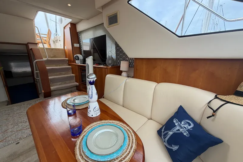 Slide: The Image of Interior of 1999 Silverton 352 Motor Yacht with dining area and nautical decor. - 57