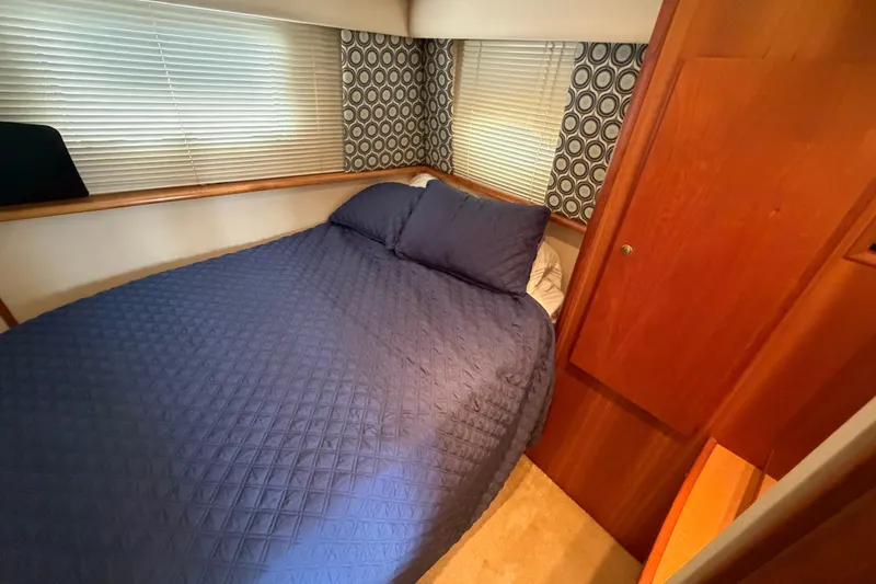 Slide: The Image of Cozy bedroom in 1999 Silverton 352 Motor Yacht with blue bedding and wood accents. - 58