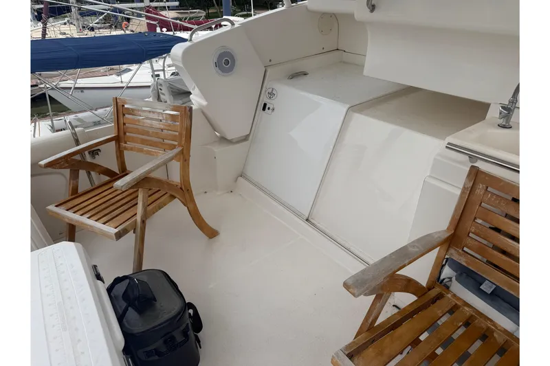 Slide: The Image of 1999 Silverton 352 Motor Yacht deck with wooden chairs and nautical equipment. - 7