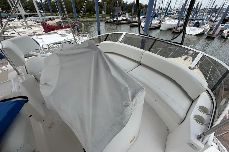 Slide: The Image of 1999 Silverton 352 Motor Yacht interior with white seating and marina view. - 9