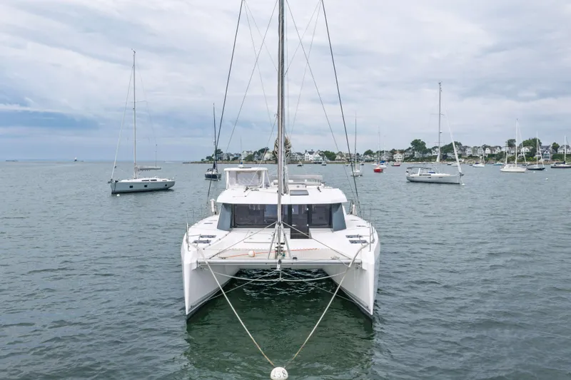 Slide: The Image of 2022 Leopard 42 catamaran anchored in a scenic harbor with sailboats. - 7