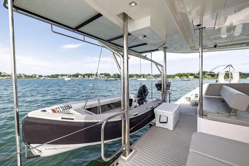 Slide: The Image of 2022 Leopard 42 yacht deck with dinghy, overlooking a scenic harbor. - 20