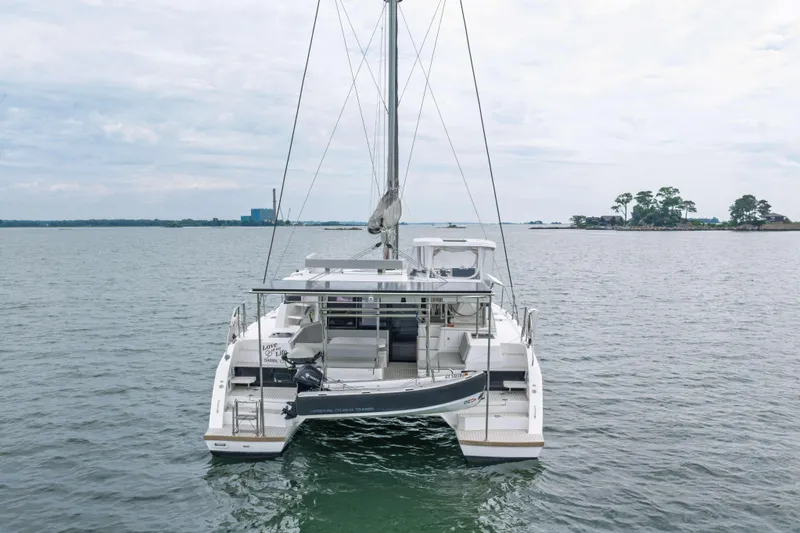 Slide: The Image of 2022 Leopard 42 catamaran on calm water, rear view with dinghy attached. - 4