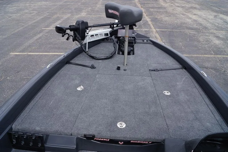 Slide: The Image of 2026 Phoenix 819 ZXL boat deck with seating and trolling motor in a parking lot. - 23