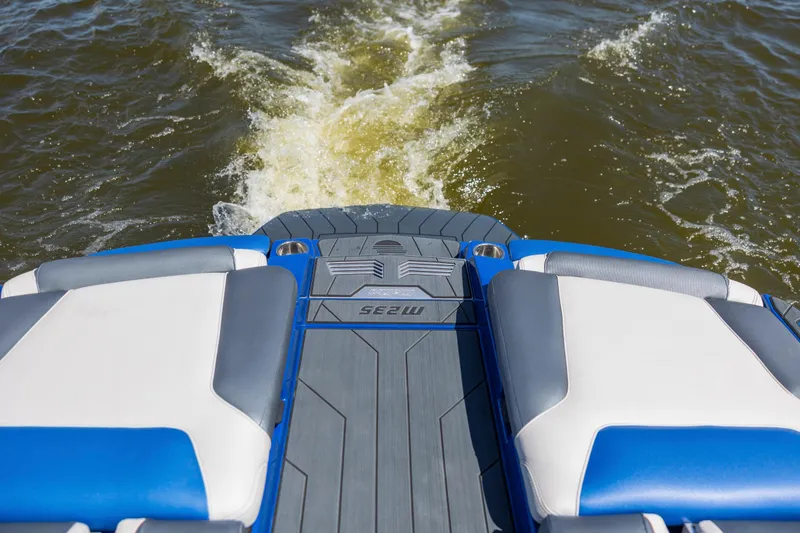 Slide: The Image of 2017 Malibu M235 boat rear view with wake on water. - 10