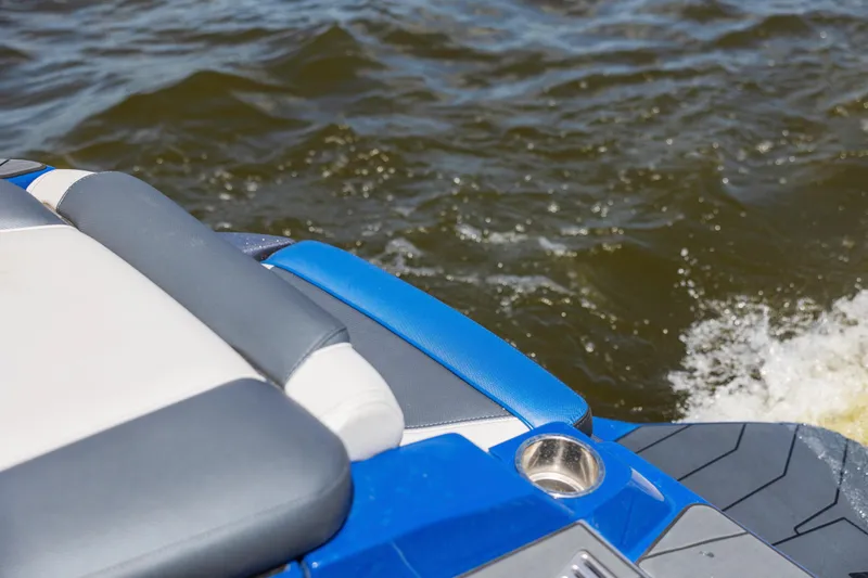 Slide: The Image of 2017 Malibu M235 boat interior with blue and gray seating on water. - 14