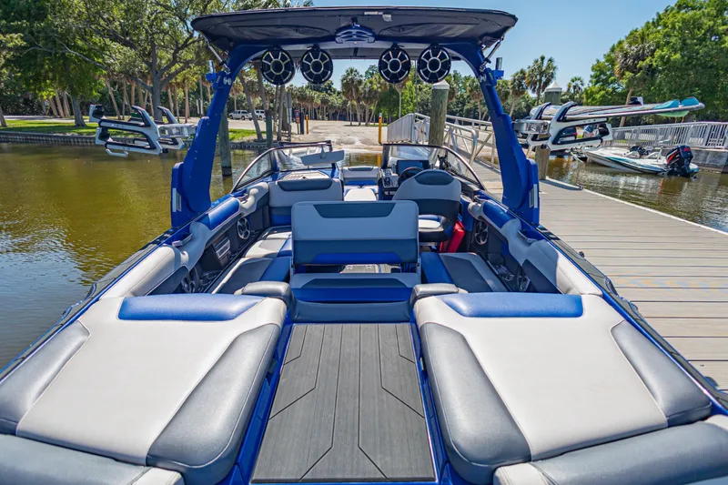 Slide: The Image of 2017 Malibu M235 boat interior with luxurious seating and advanced audio system at a dock. - 16