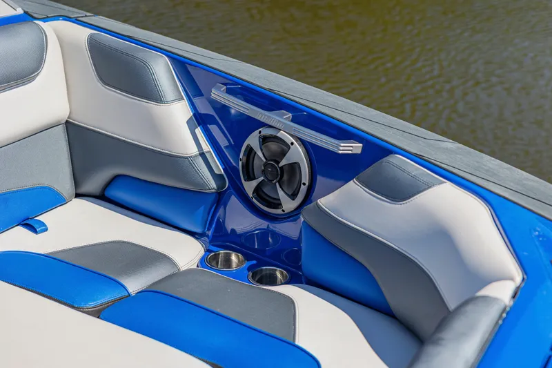 Slide: The Image of 2017 Malibu M235 boat interior with blue and gray seating, speaker, and cup holders. - 32