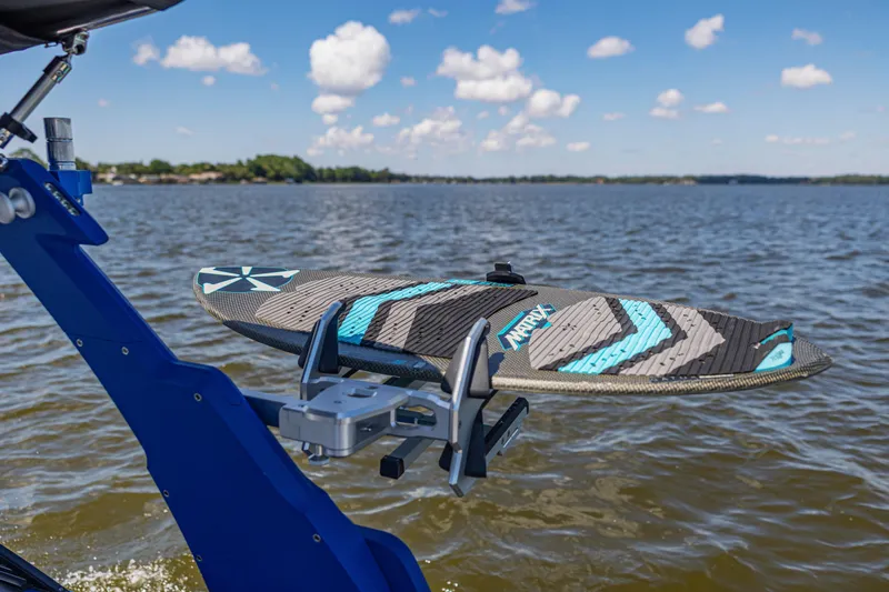 Slide: The Image of Surfboard mounted on a 2017 Malibu M235 boat against a scenic lake backdrop. - 39
