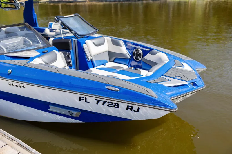 Slide: The Image of Blue and white 2017 Malibu M235 boat docked on calm water. - 41