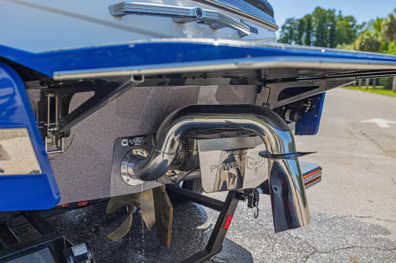 Slide: The Image of Rear view of a 2017 Malibu M235 boat showcasing its polished exhaust system. - 48