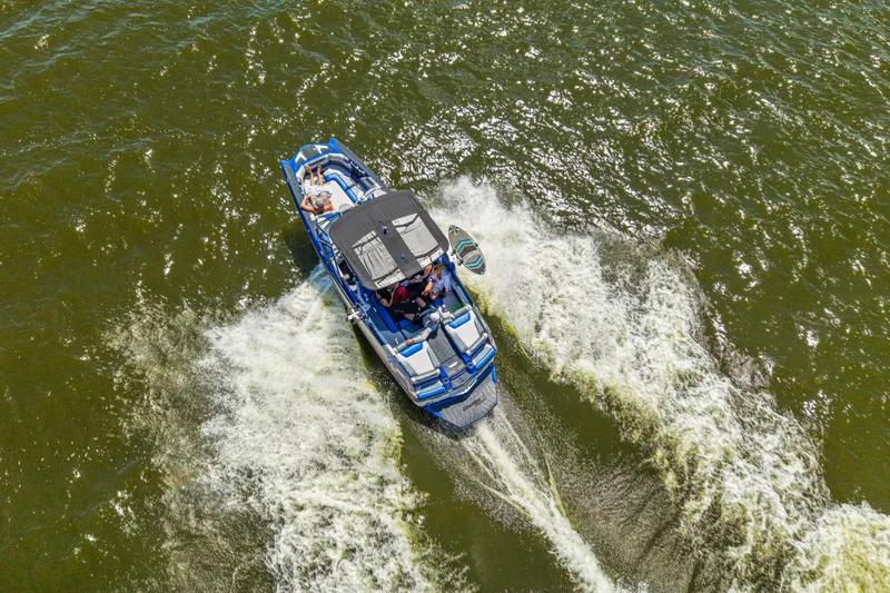Slide: The Image of Aerial view of 2017 Malibu M235 boat cruising on water, creating a wake. - 6