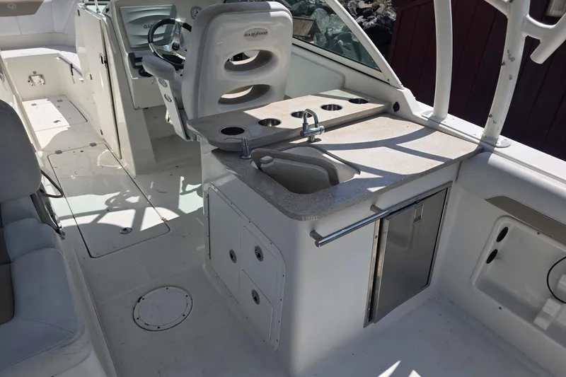 Slide: The Image of 2016 Sailfish 275 DC boat interior with helm, sink, and seating area. - 2