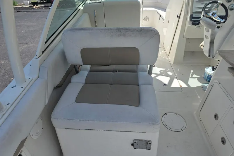 Slide: The Image of Interior seating of a 2016 Sailfish 275 DC boat, featuring cushioned seats and steering area. - 5