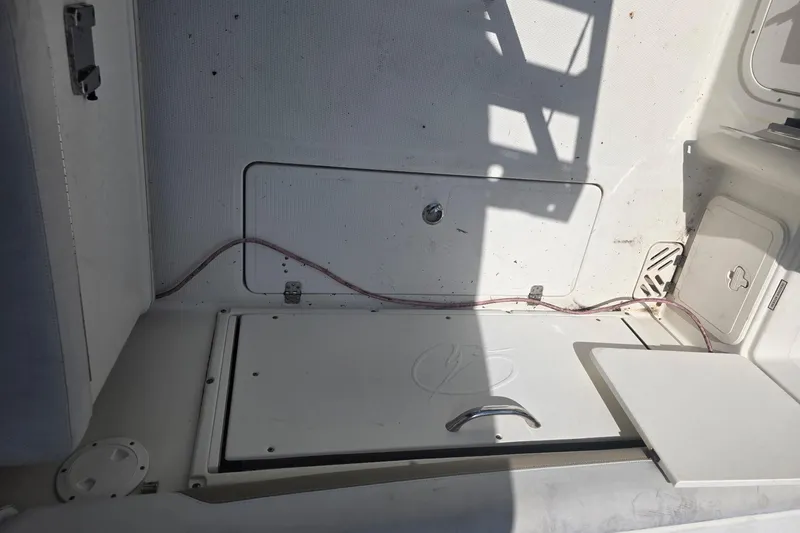 Slide: The Image of 2016 Sailfish 275 DC boat interior with storage compartments and wiring. - 7