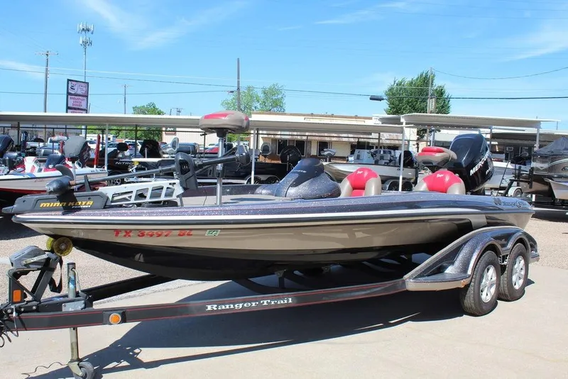 Slide: The Image of 2011 Ranger Z120 Comanche boat on trailer, displayed outdoors at a dealership. - 13