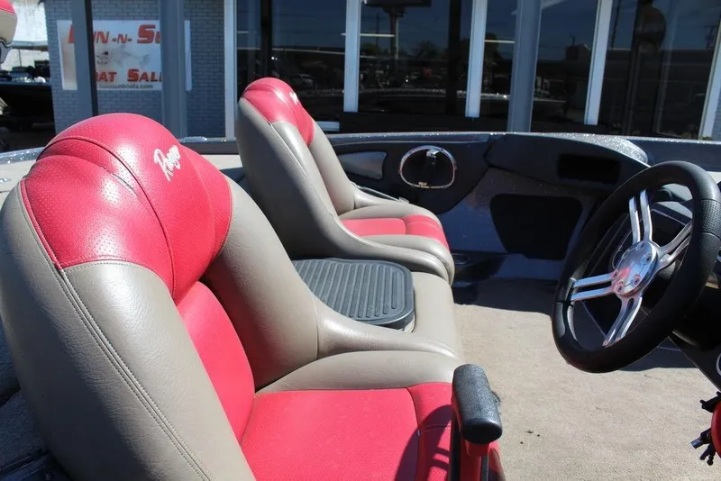Slide: The Image of Interior of 2011 Ranger Z120 Comanche boat with red and beige seats, steering wheel visible. - 14