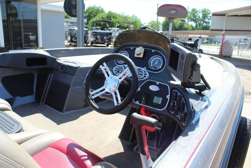 Slide: The Image of 2011 Ranger Z120 Comanche boat cockpit with steering wheel and control panel. - 15