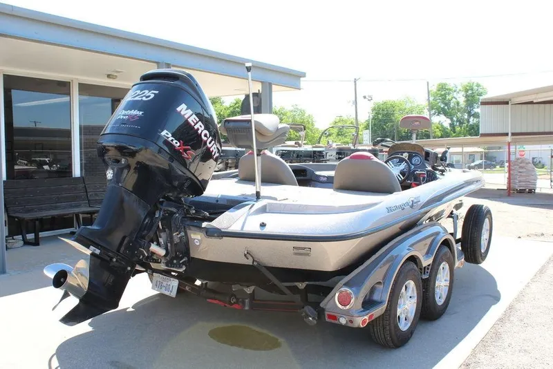Slide: The Image of 2011 Ranger Z120 Comanche boat with Mercury Pro XS engine, parked outdoors. - 2