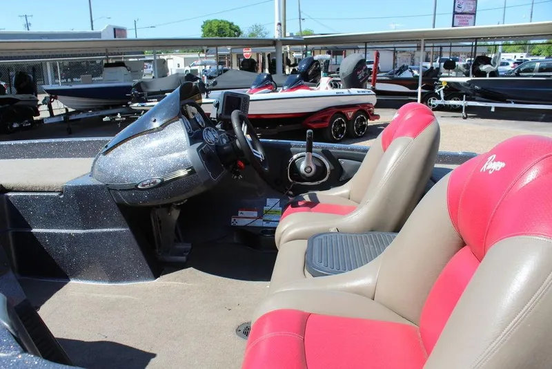 Slide: The Image of 2011 Ranger Z120 Comanche boat interior with red and beige seats, steering console, and dashboard. - 3