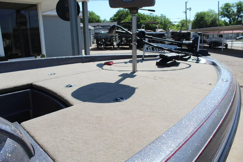 Slide: The Image of 2011 Ranger Z120 Comanche boat deck with fishing equipment, parked outdoors. - 7