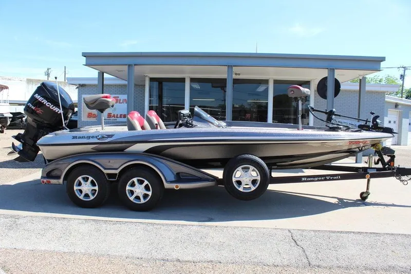 Slide: The Image of 2011 Ranger Z120 Comanche boat with Mercury engine, parked on a trailer outside a dealership. - 8