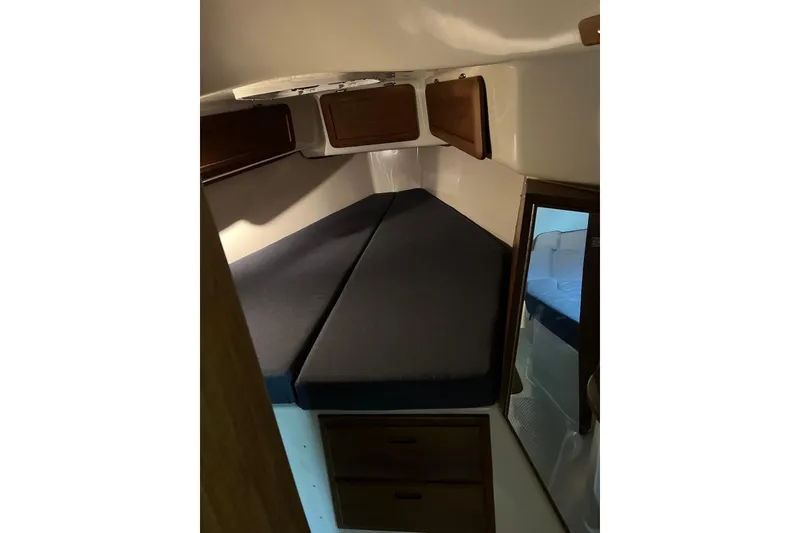 Slide: The Image of 1999 Hake Yachts Seaward Eagle 32 cabin interior with dark cushions and wooden storage. - 34