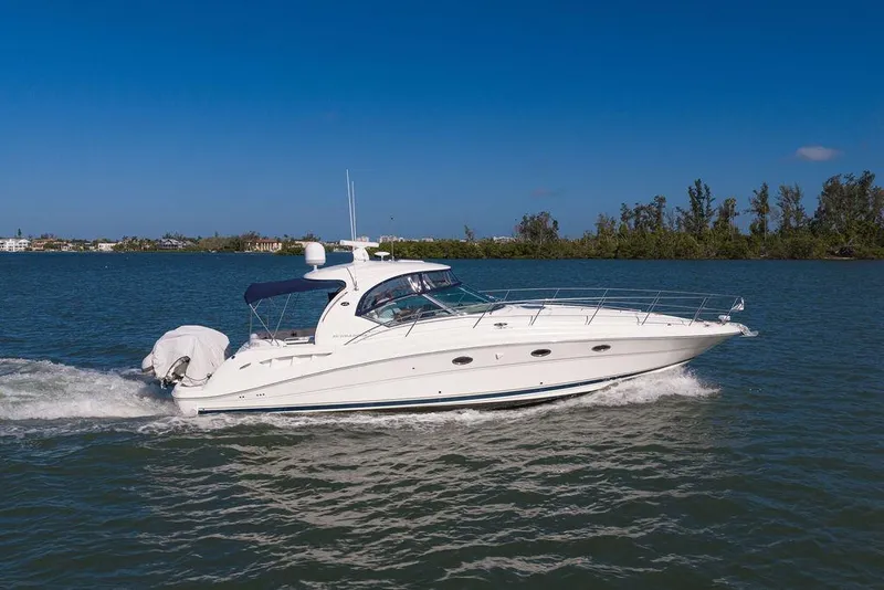 Slide: The Image of 2005 Sea Ray 420 Sundancer cruising on a sunny day, surrounded by calm waters. - 12