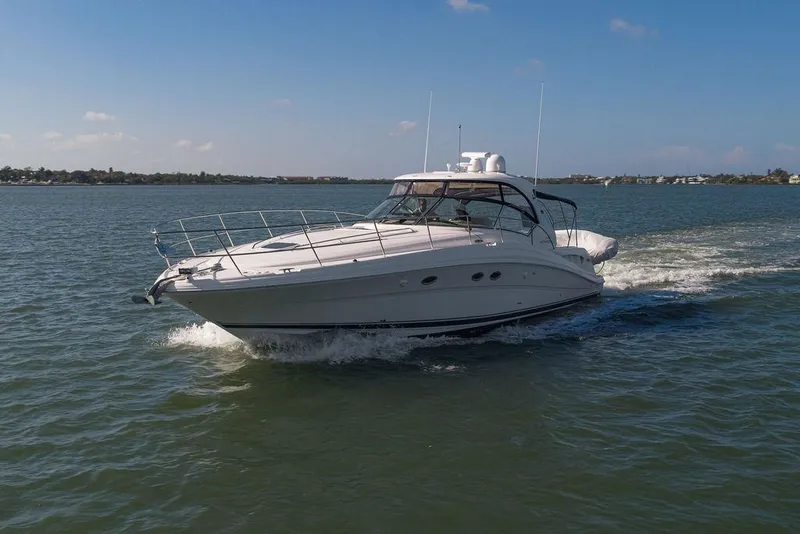 Slide: The Image of 2005 Sea Ray 420 Sundancer cruising on open water under clear skies. - 14