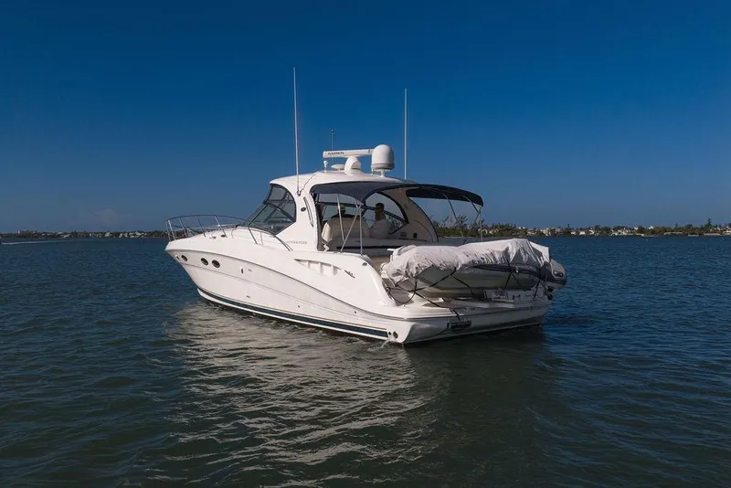 Slide: The Image of 2005 Sea Ray 420 Sundancer yacht cruising on calm waters under clear blue skies. - 19