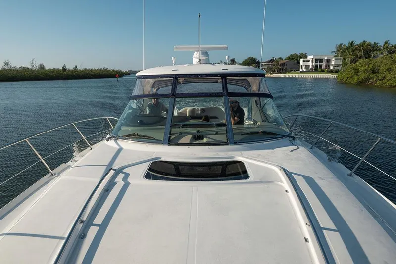 Slide: The Image of 2005 Sea Ray 420 Sundancer cruising on a calm waterway under clear blue skies. - 21