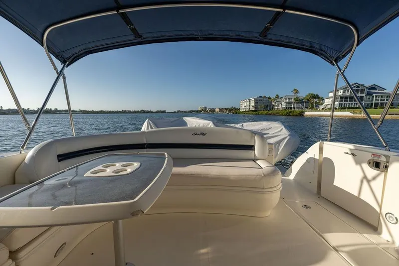 Slide: The Image of 2005 Sea Ray 420 Sundancer boat interior with seating and table, overlooking waterfront homes. - 27