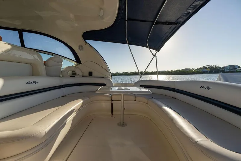 Slide: The Image of 2005 Sea Ray 420 Sundancer interior with seating and table, overlooking serene water view. - 29