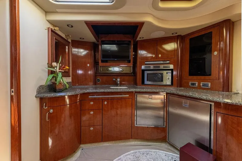 Slide: The Image of Luxurious 2005 Sea Ray 420 Sundancer yacht kitchen with wood cabinetry and modern appliances. - 33