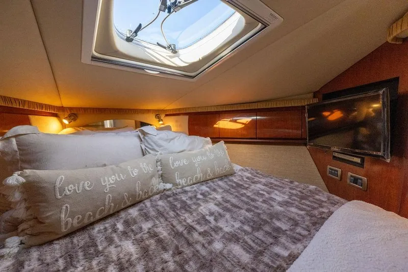 Slide: The Image of Luxurious cabin interior of 2005 Sea Ray 420 Sundancer with skylight and cozy bedding. - 49