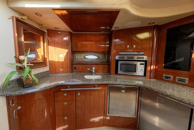 Slide: The Image of Luxurious 2005 Sea Ray 420 Sundancer yacht kitchen with wood cabinetry and modern appliances. - 52