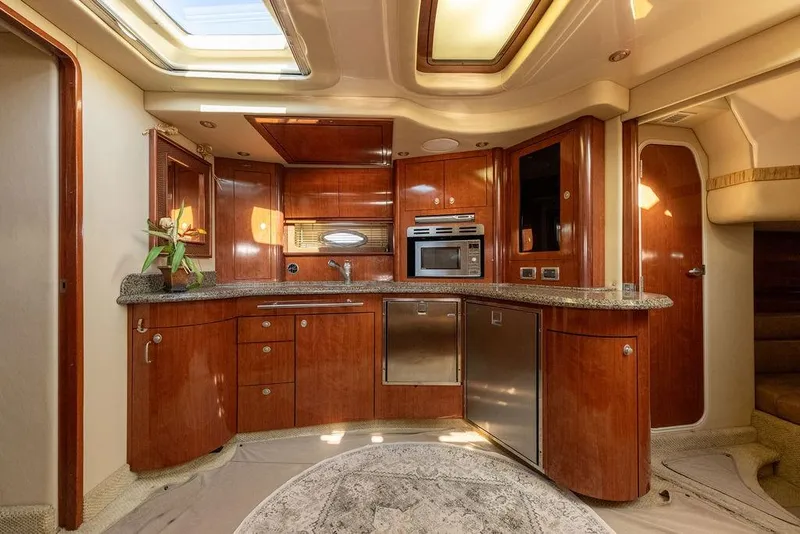Slide: The Image of Luxurious 2005 Sea Ray 420 Sundancer yacht kitchen with wood cabinetry and modern appliances. - 55