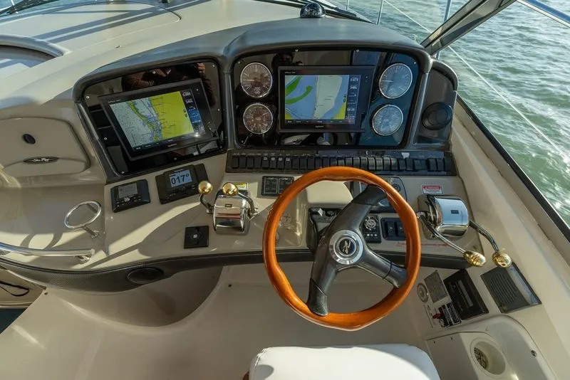 Slide: The Image of Helm of 2005 Sea Ray 420 Sundancer with navigation screens and wooden steering wheel. - 65
