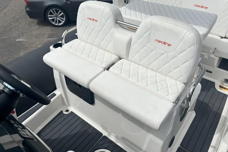 Slide: The Image of 2026 Zodiac Medline 7.5 GT boat interior with white quilted seating and steering wheel. - 13