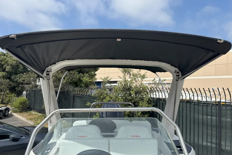 Slide: The Image of 2026 Zodiac Medline 7.5 GT boat with canopy, parked outdoors under a clear sky. - 16