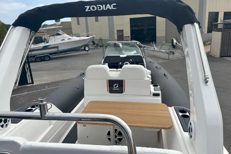 Slide: The Image of 2026 Zodiac Medline 7.5 GT boat interior with seating and table, docked at a marina. - 6