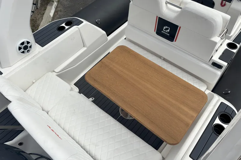 Slide: The Image of 2026 Zodiac Medline 7.5 GT boat interior with white seating and wooden table. - 7