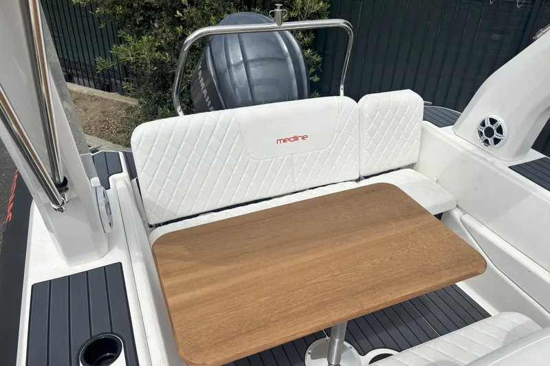 Slide: The Image of Luxurious seating area on 2026 Zodiac Medline 7.5 GT boat with wooden table. - 8