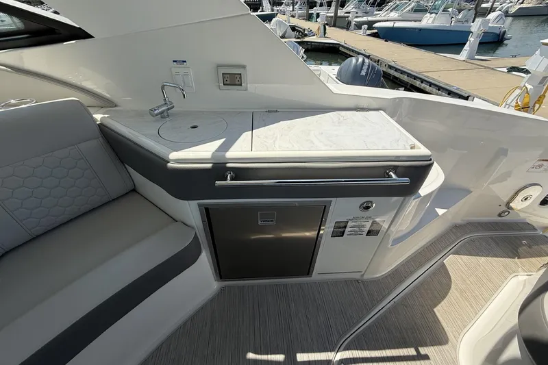 Slide: The Image of Interior of 2023 Sea Ray Sundancer 320 yacht with kitchenette and seating area. - 16