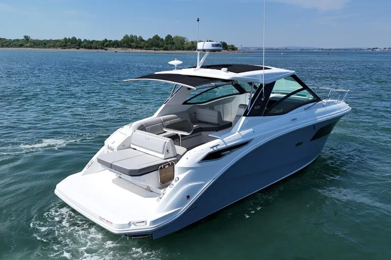 Slide: The Image of 2023 Sea Ray Sundancer 320 yacht cruising on a serene blue lake. - 2