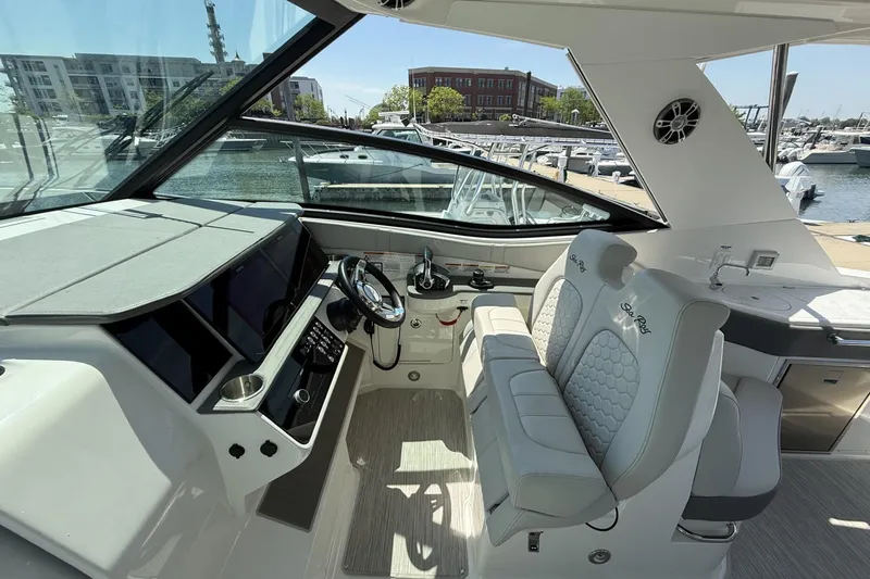 Slide: The Image of 2023 Sea Ray Sundancer 320 cockpit with modern helm, plush seating, and marina view. - 20