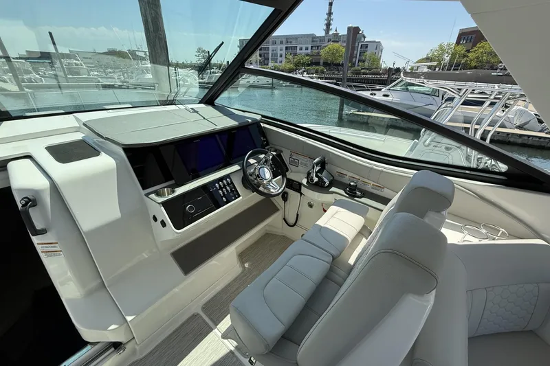 Slide: The Image of 2023 Sea Ray Sundancer 320 helm with modern controls and waterfront view. - 21
