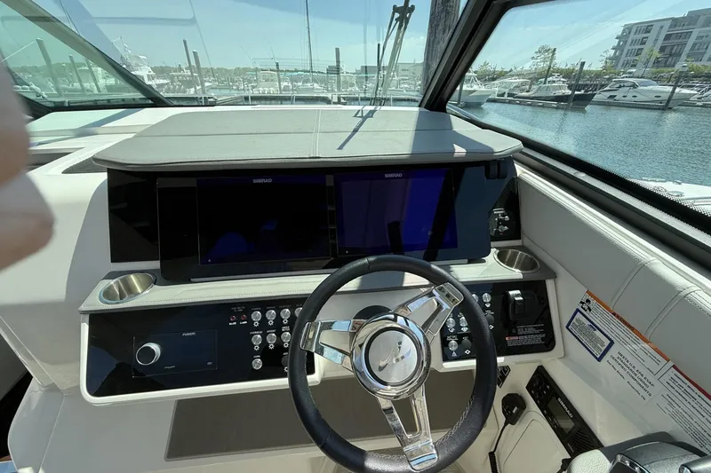 Slide: The Image of Cockpit of 2023 Sea Ray Sundancer 320 with modern controls and steering wheel. - 22